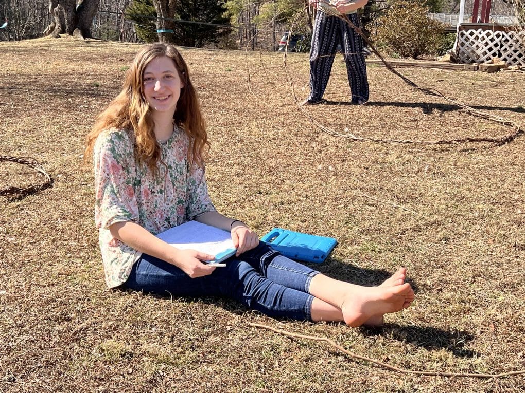 girl writing a letter outside on a warm winter day