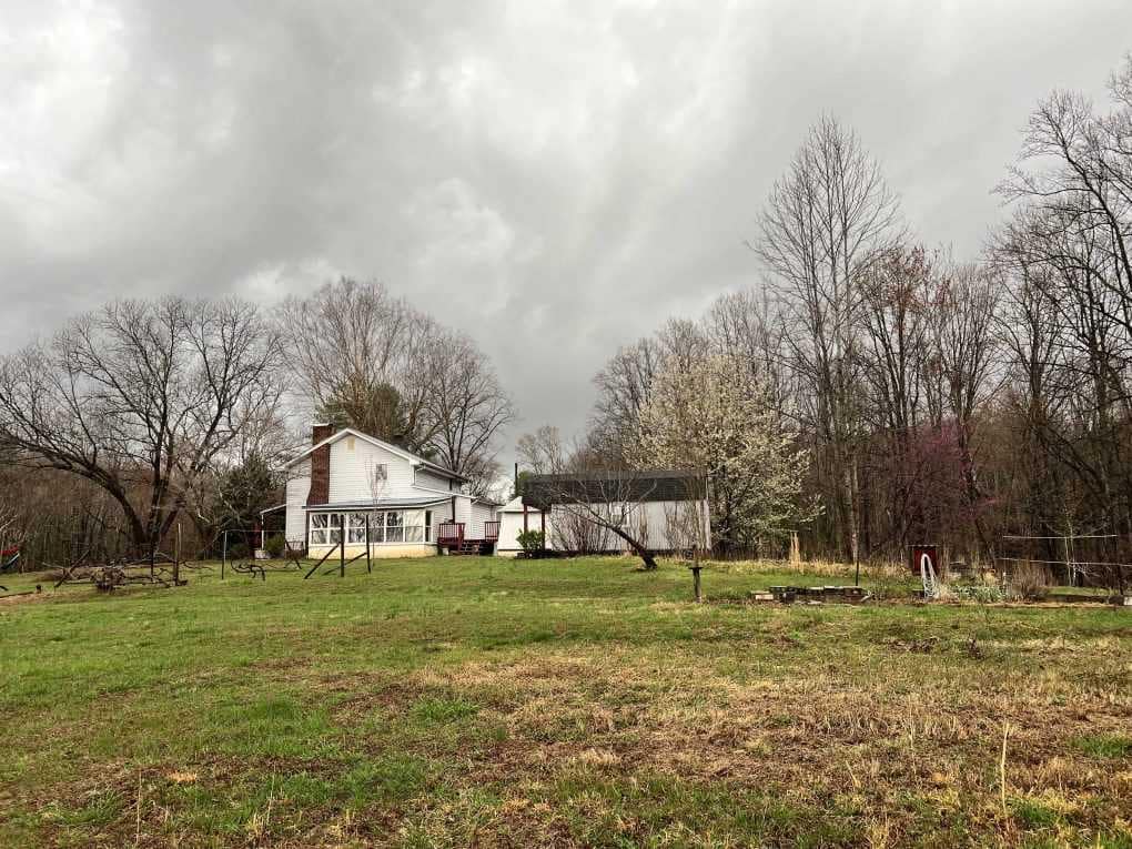country farmhouse with storm clouds in the sky