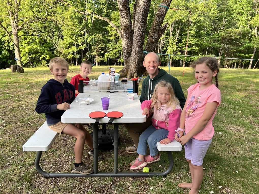 Dad and 4 kids at picnic table