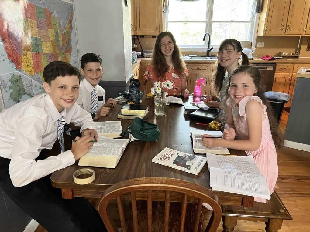5 kids reading scriptures at the table