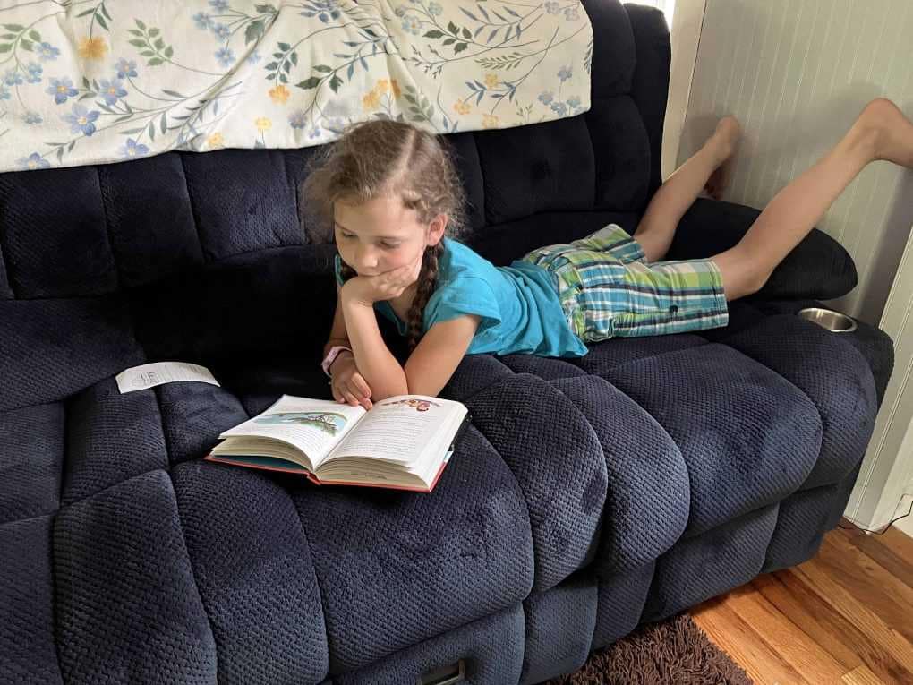 8 year old girl reading on couch