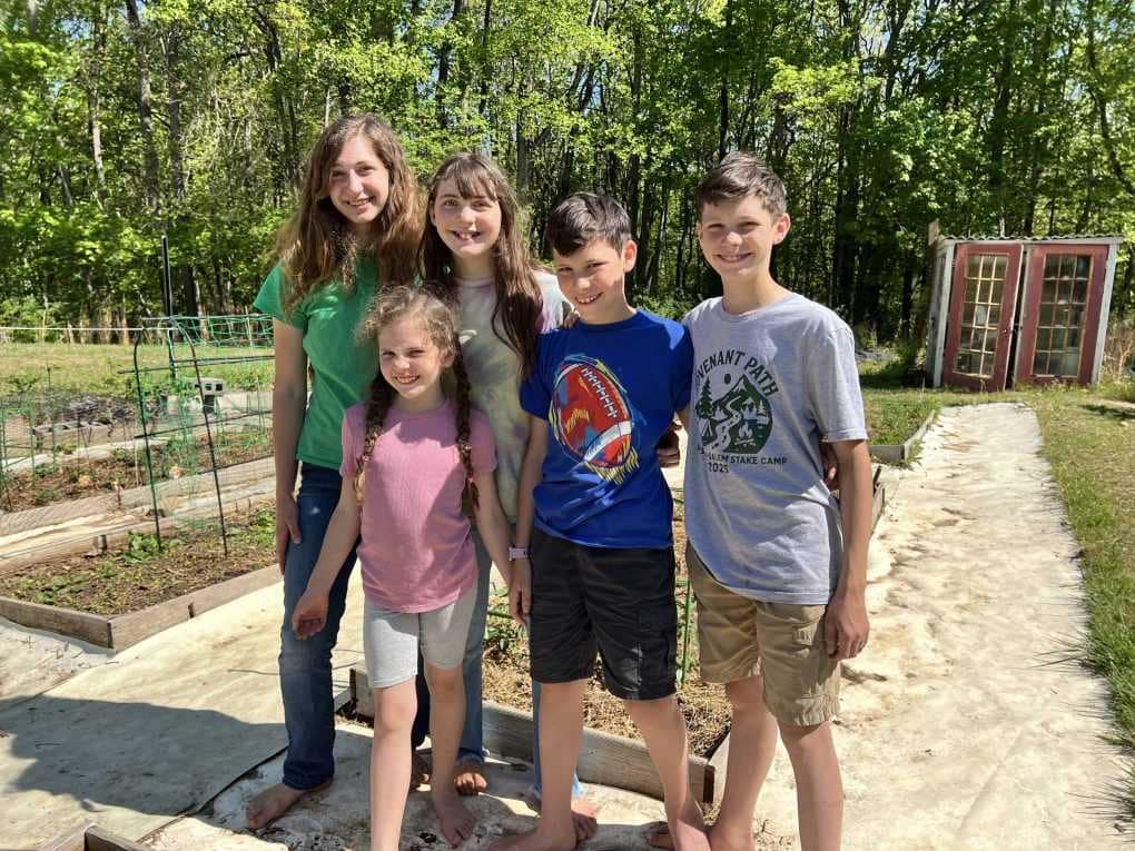 5 kids in front of garden beds