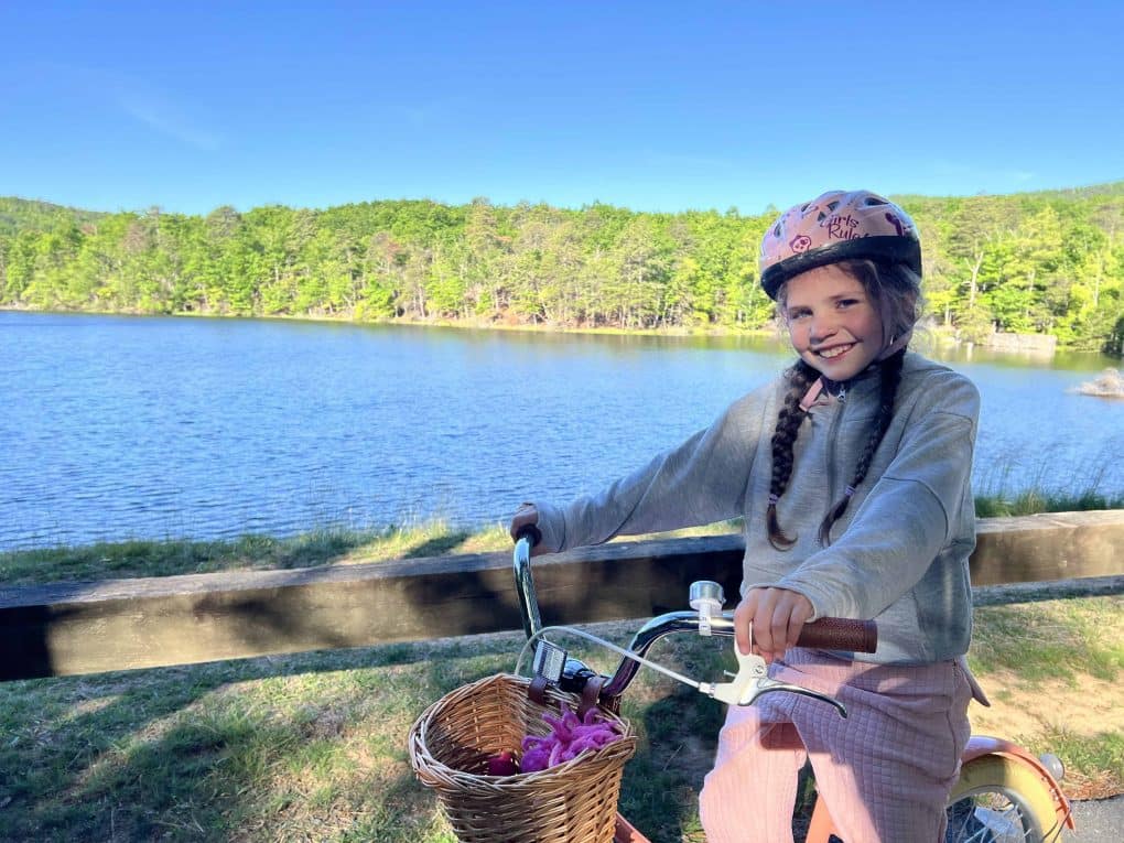 girl on bike in front of lake