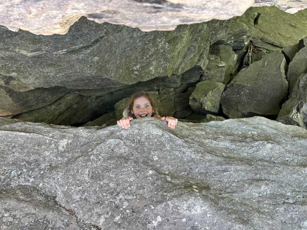 girl pretending to hang off a rock