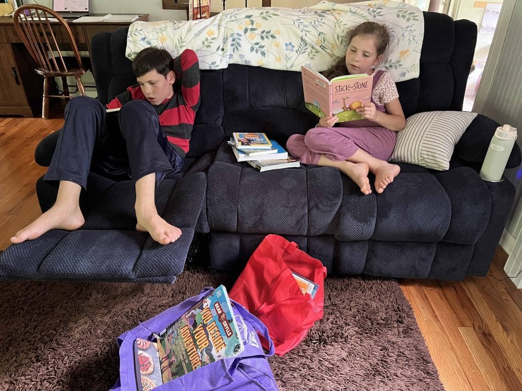 two kids reading on the couch