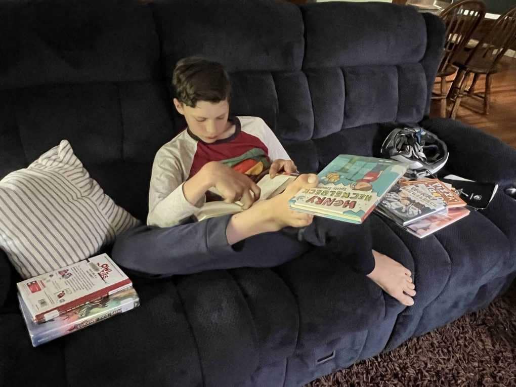 12 year old boy reading on couch