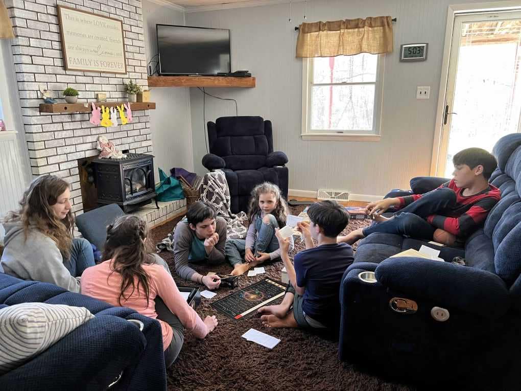 6 kids playing board games on the living room floor