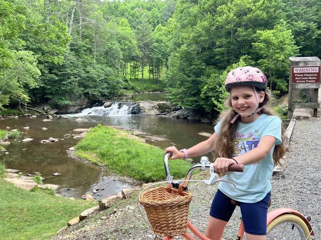 girl on a bike ride at a waterfall