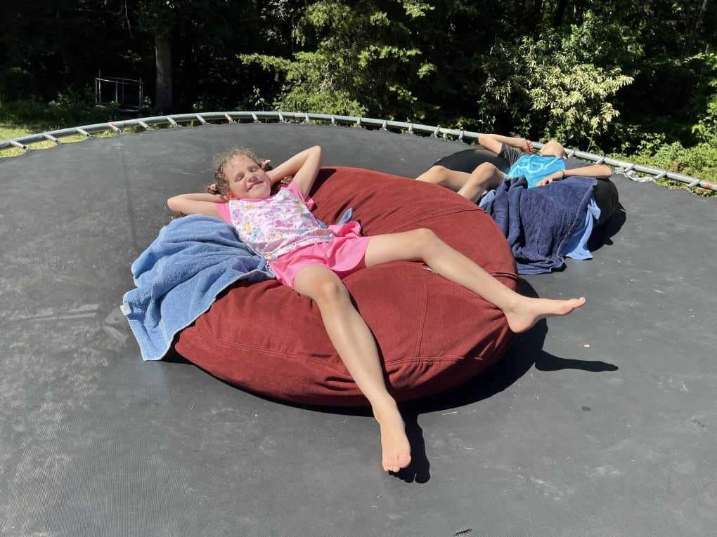 kids sunbathing on trampoline
