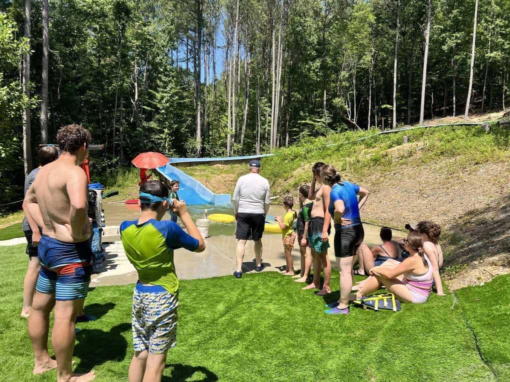 kids standing at the bottom of a waterslide