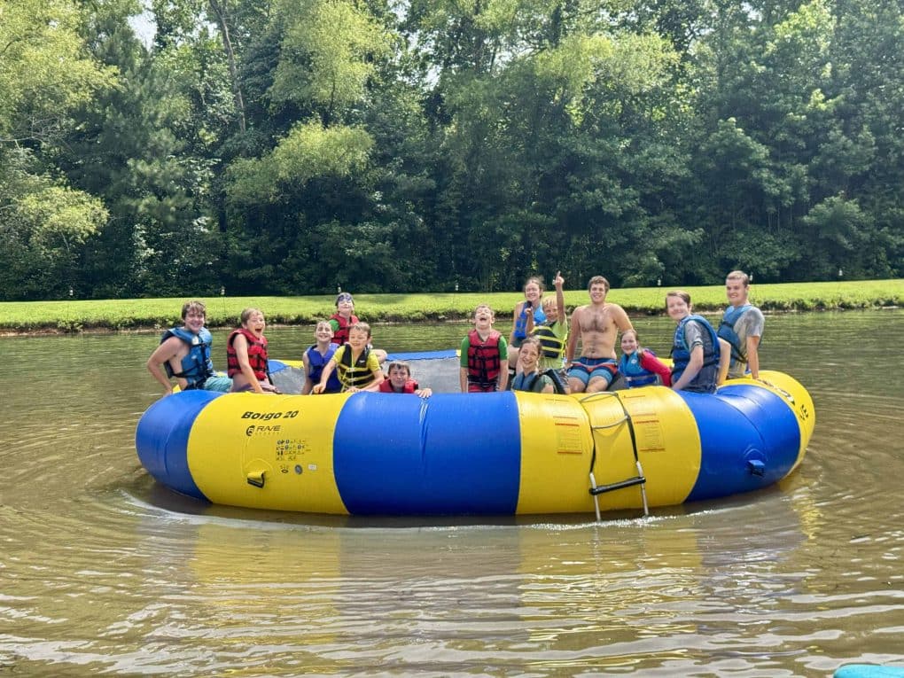 cousins on water trampoline on lake