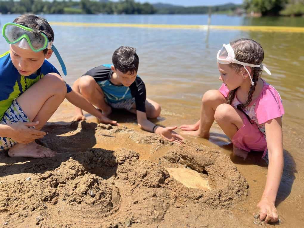 3 siblings building a sand castle