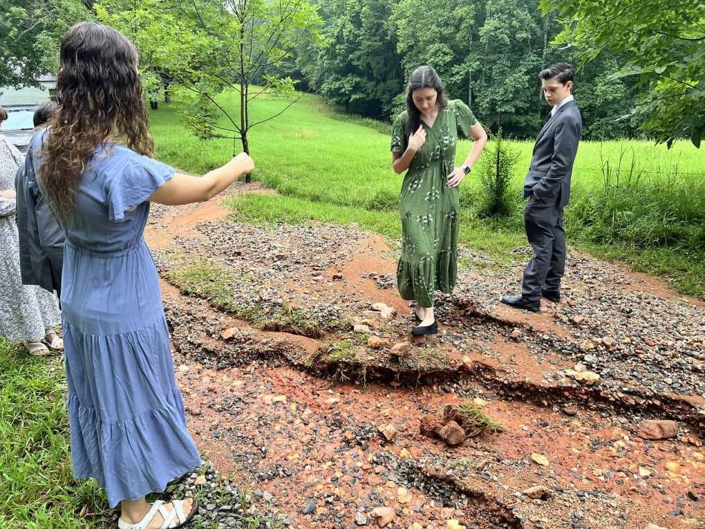siblings looking at a flooded driveway