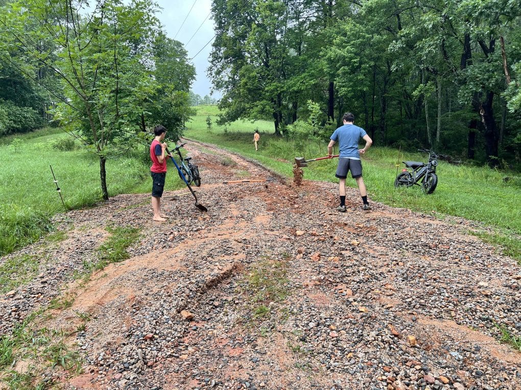 family fixing washed away driveway