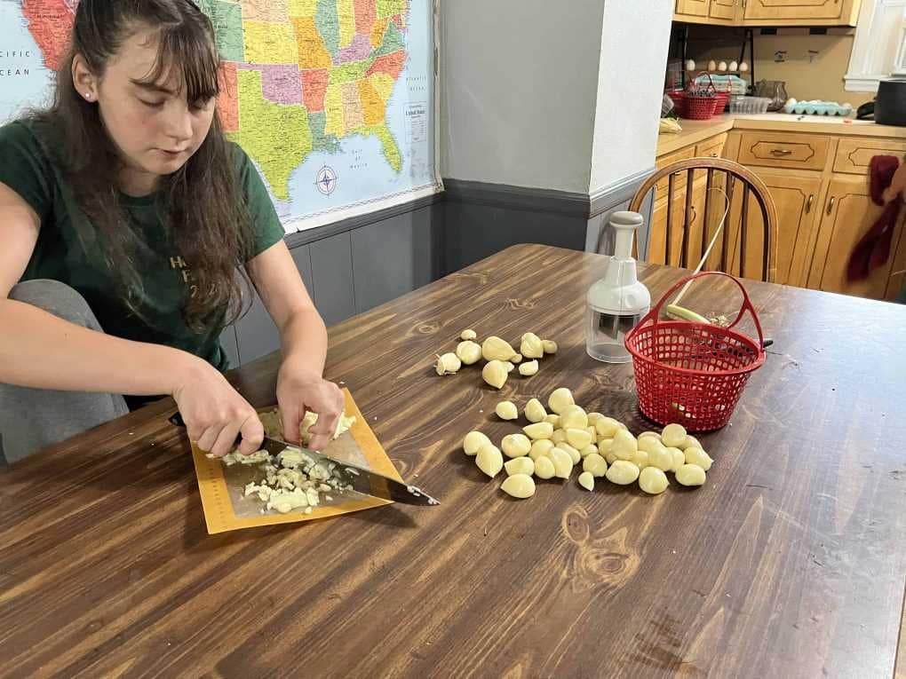 teen girl chopping garlic