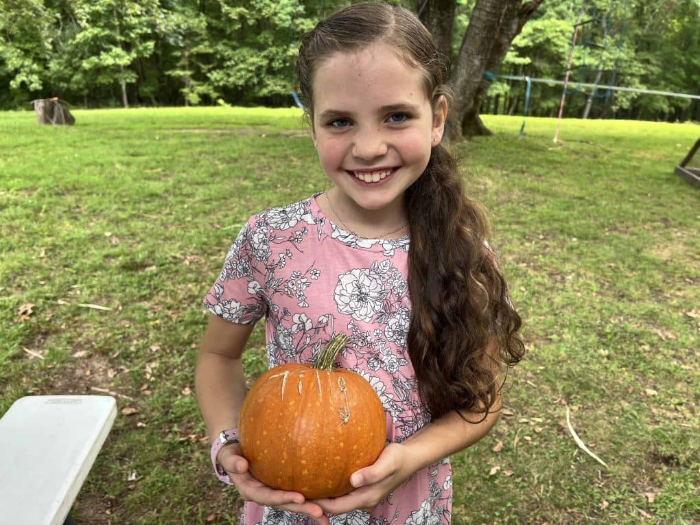 girl holding her pumpkin