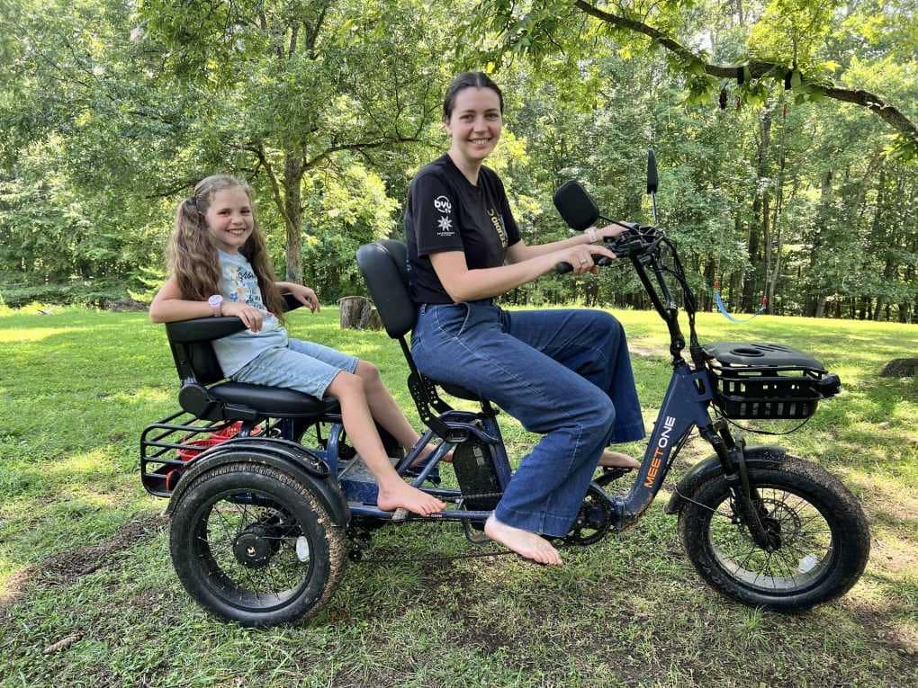 older sister and younger sister riding an etrike