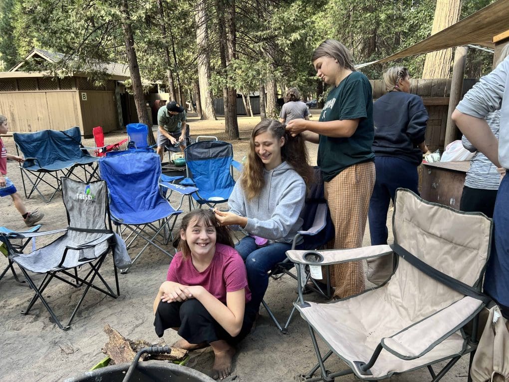 3 girls braiding each other's hair