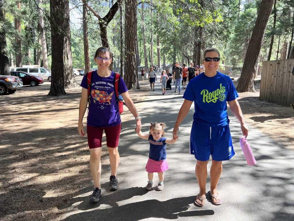 two sisters walking with baby in between them