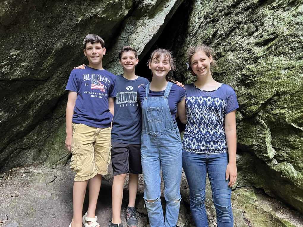 4 siblings in front of a cave