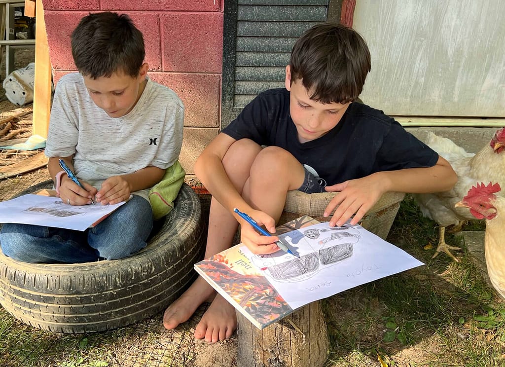 boy sitting in a tire and barrel drawing