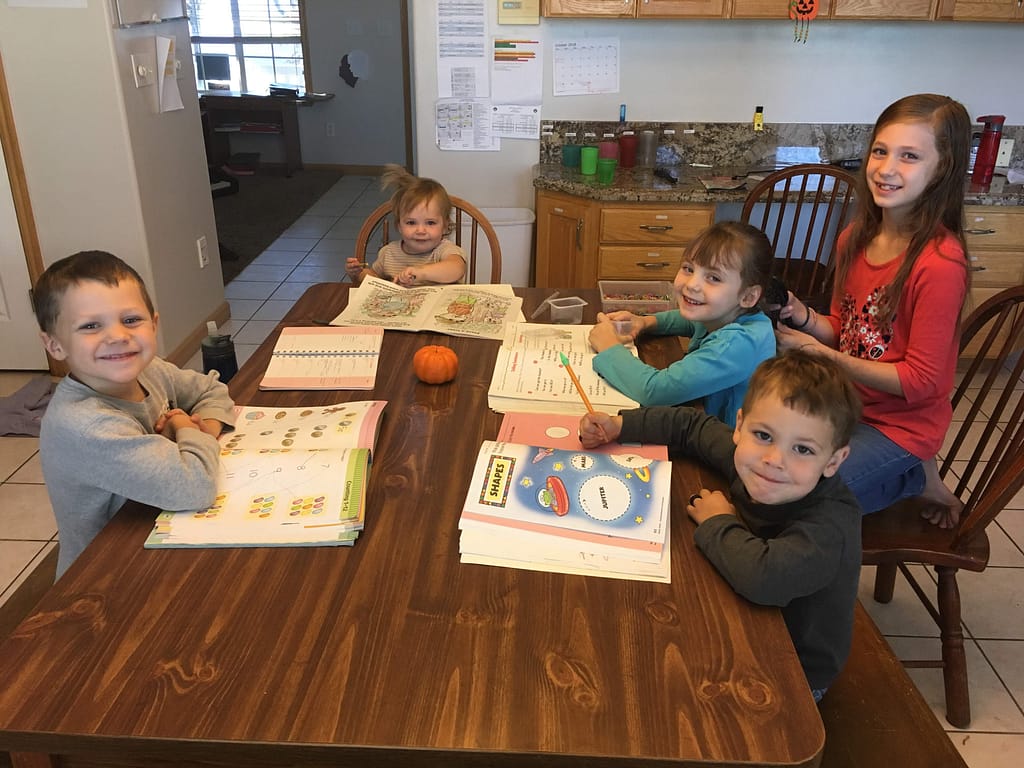 5 kids at a table doing homeschool