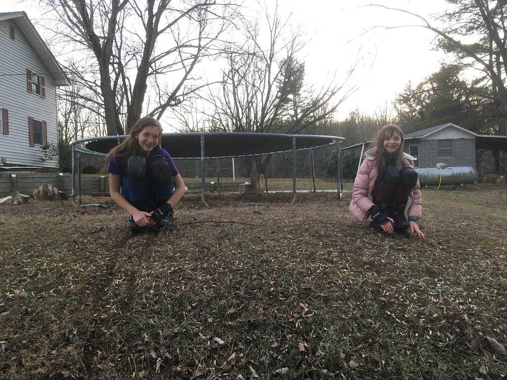 two sisters skating down a hill as they play outside