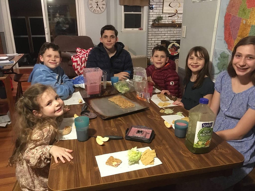 Family around a dinner table at night.
