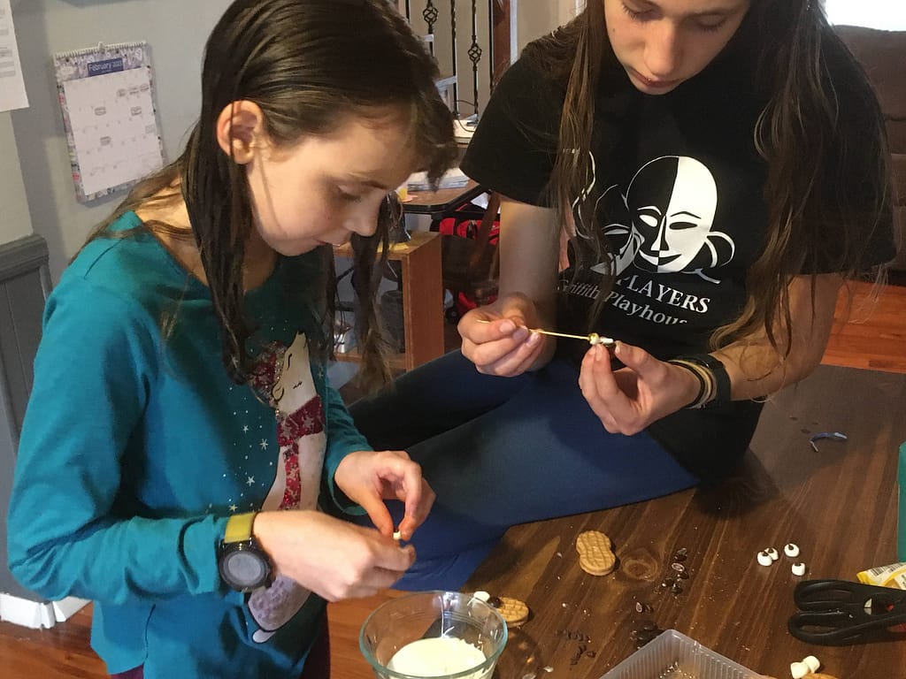 2 girls making eyes for groundhog cupcakes