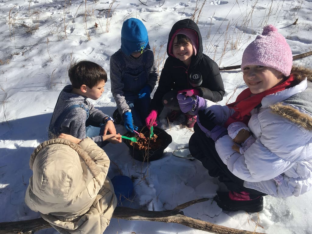 5 kids eat a pot of beans in the snow, pretending to be like Washington's troops in Valley Forge