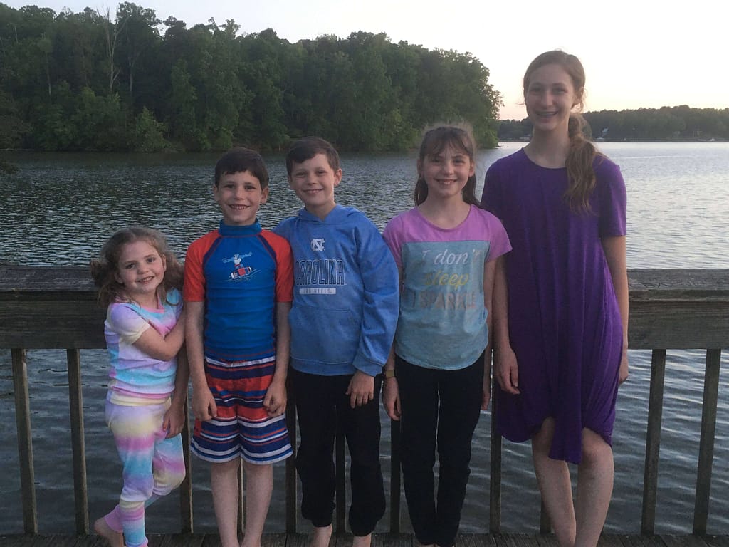 5 siblings standing on the fishing dock at Lake Norman