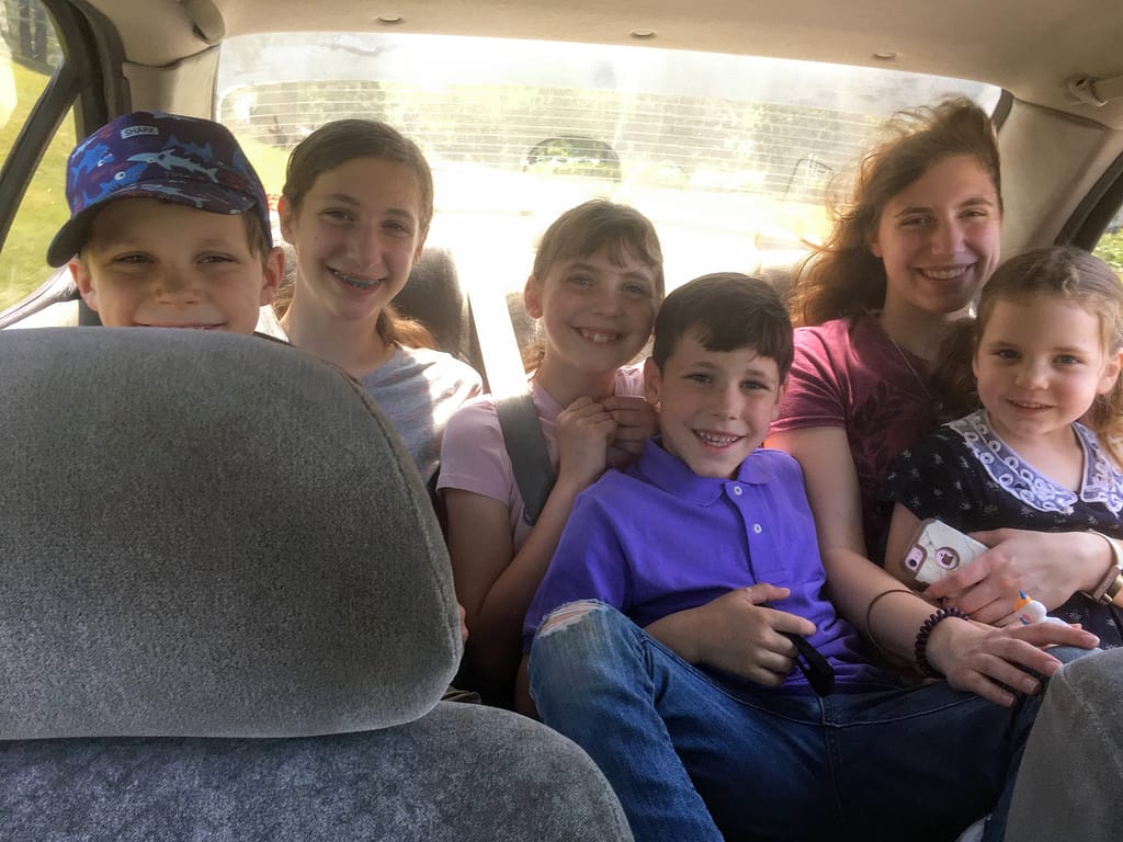 6 kids squished in the back of a car