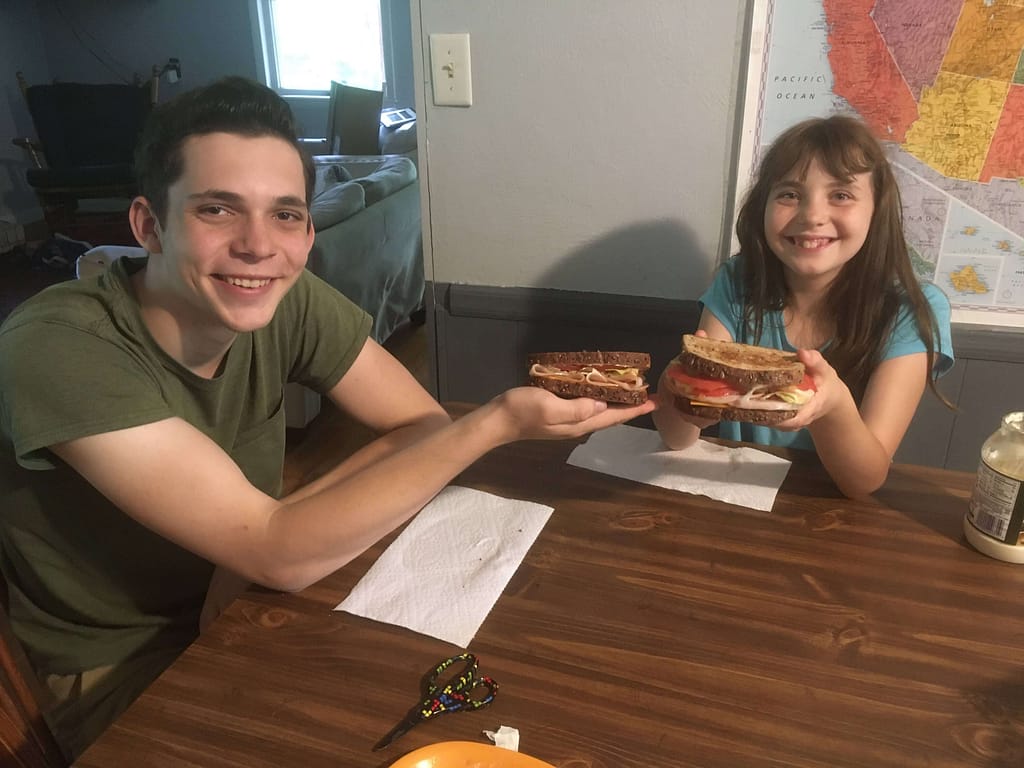 two siblings show their delicious sandwiches they made