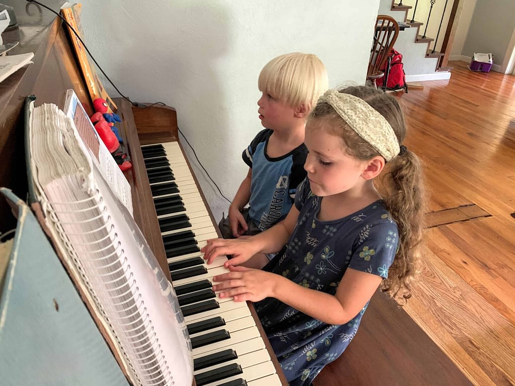 two little kids playing the piano together