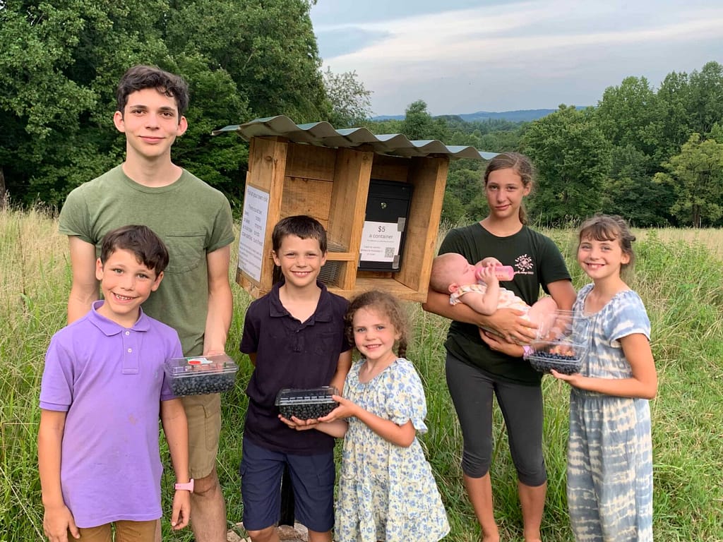 Seven kids stand by their blueberry cash box on Blueberry Hill