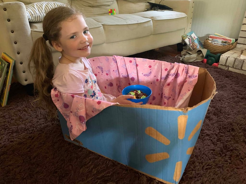 6 year old watching a show in a cardboard box train