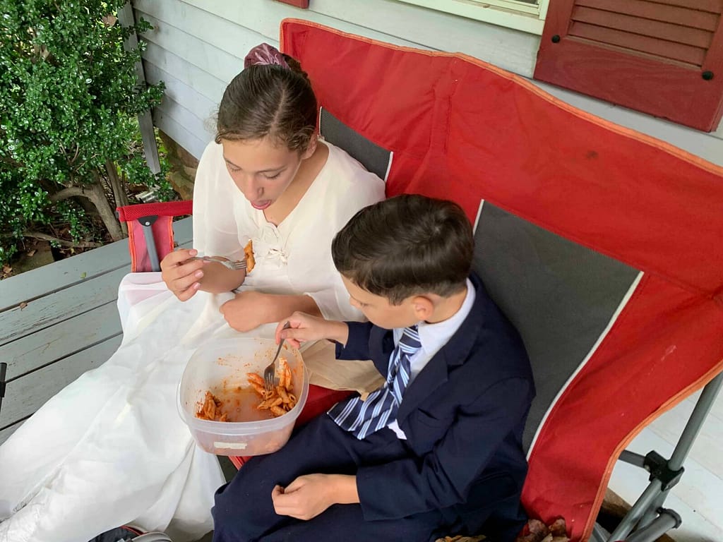 boy and girl share a container of pasta