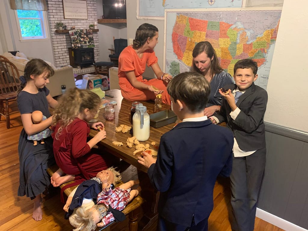 family eating homemade bread, jam, butter, and raw milk