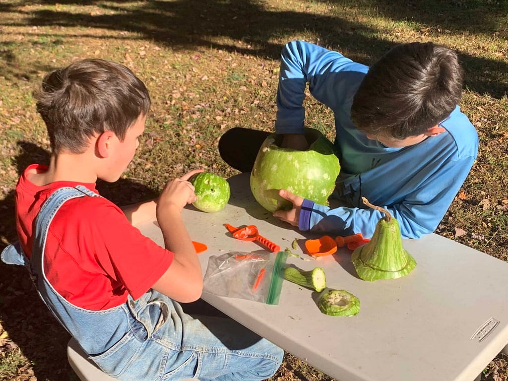 two boys carve gourds