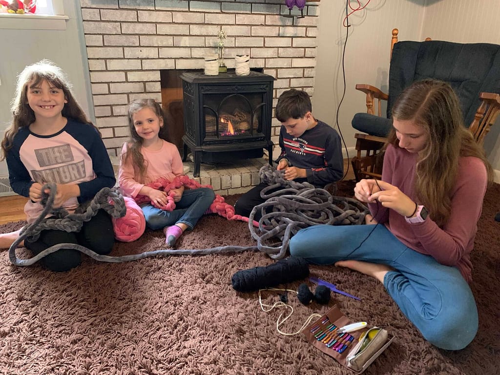 kids finger crocheting by the fire