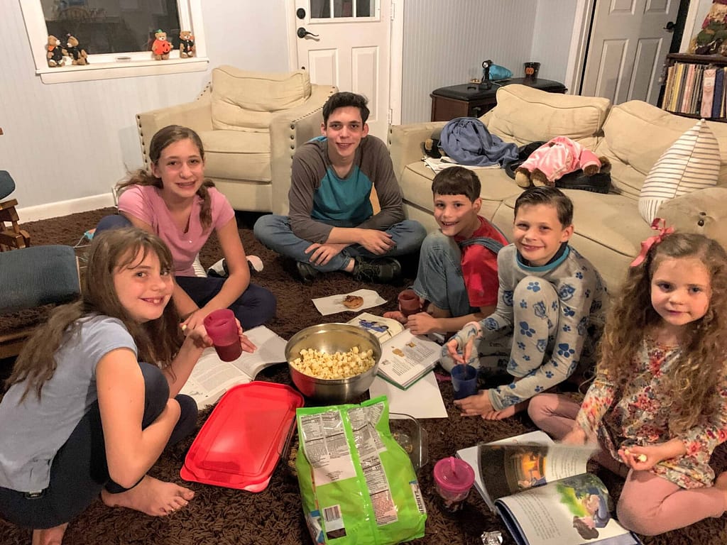 family of 6 kids eating popcorn and reading books