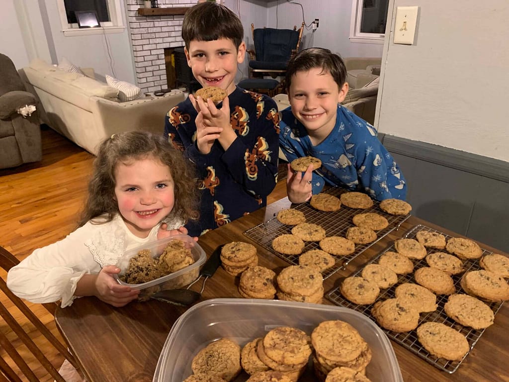 3 kids smiling with the cookies they just made