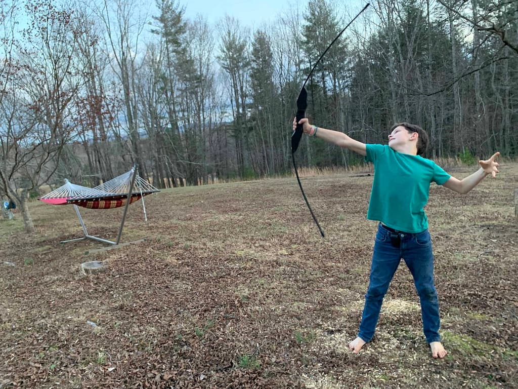 10 year old boy shooting a bow and arrow