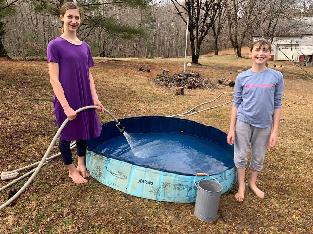 2 girls filling a kiddie pool