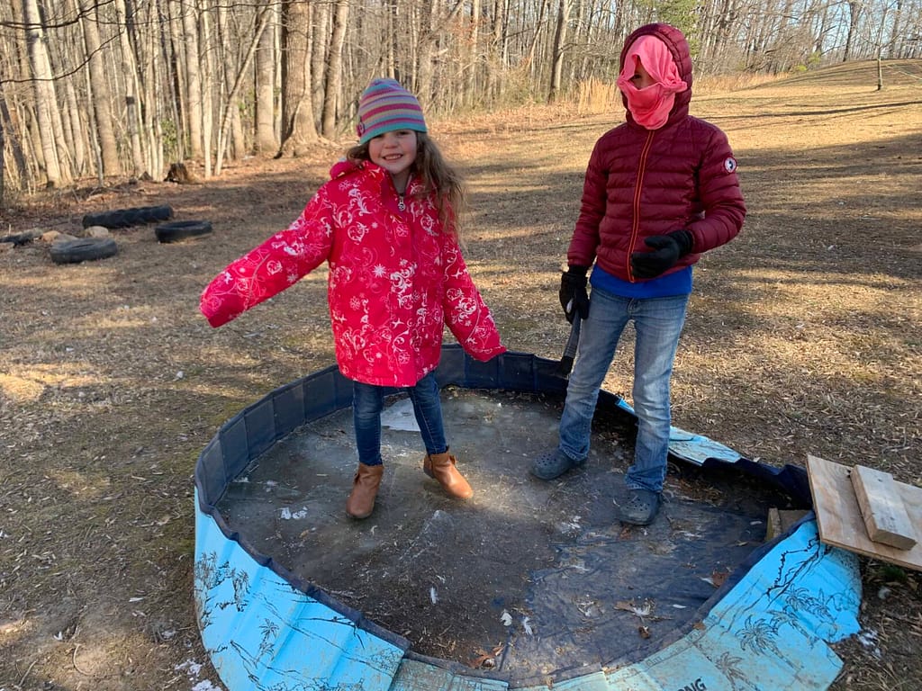 2 kids skating on frozen swimming pool