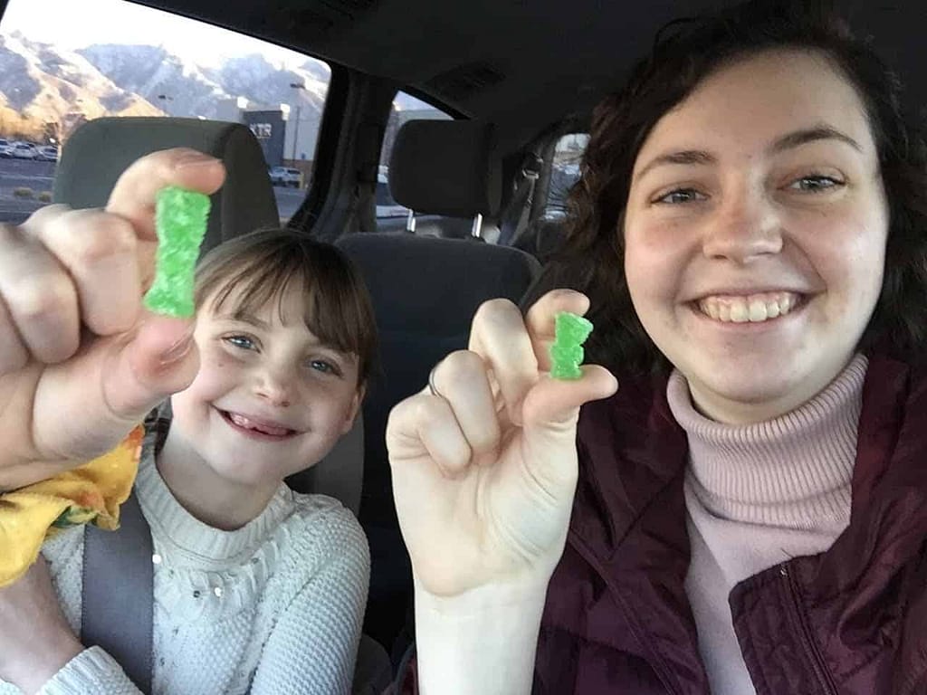two sisters eat gummy bears in the car