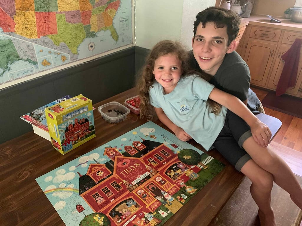 16 year old brother doing a puzzle with 6 year old sister