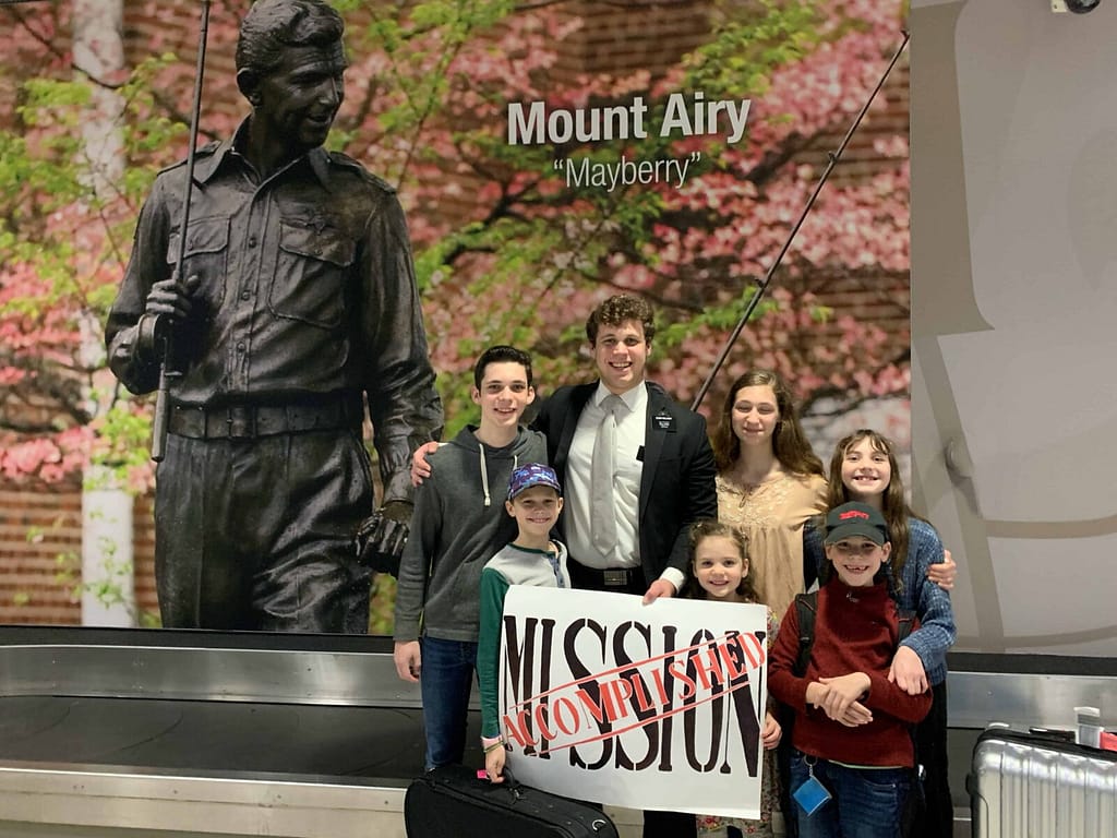 family posed at the GSO airport