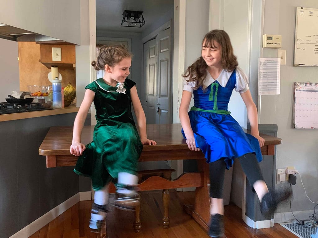 two sisters doing a dance on the table