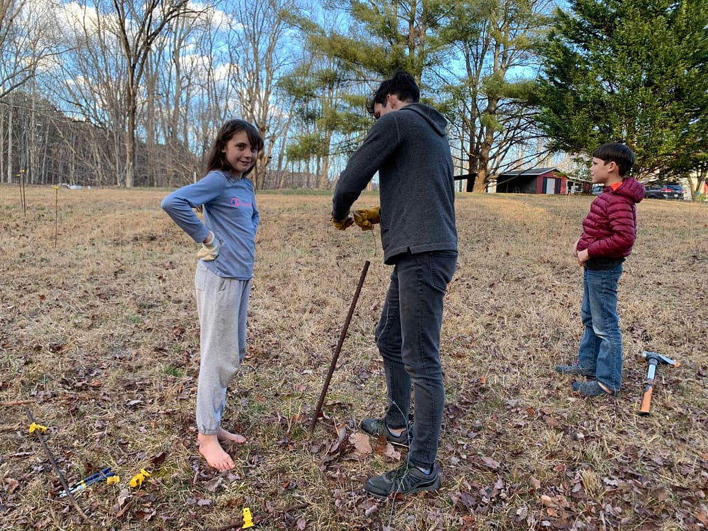 teenagers putting up an electric cattle fence